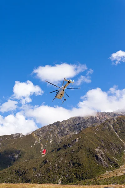 Transport helicopter fly over mountain wilderness — Stock Photo, Image