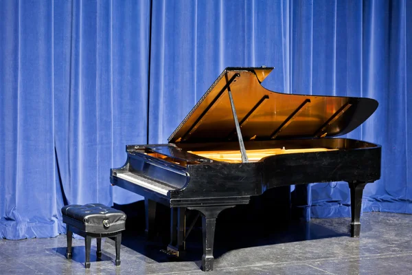 Piano de cauda aberto no palco com cortinas de veludo azul — Fotografia de Stock