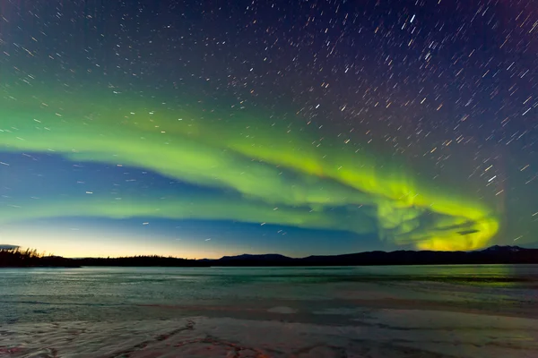 Nordlichter und Morgengrauen über dem zugefrorenen See lizenzfreie Stockfotos