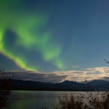Aurora borealis bulutlar üzerinde göl Laberge ay yaktı