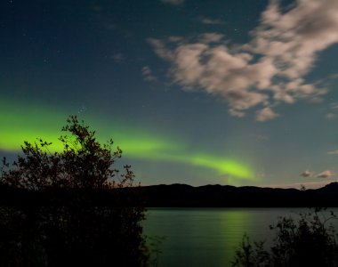 Aurora borealis bulutlar üzerinde göl Laberge ay yaktı