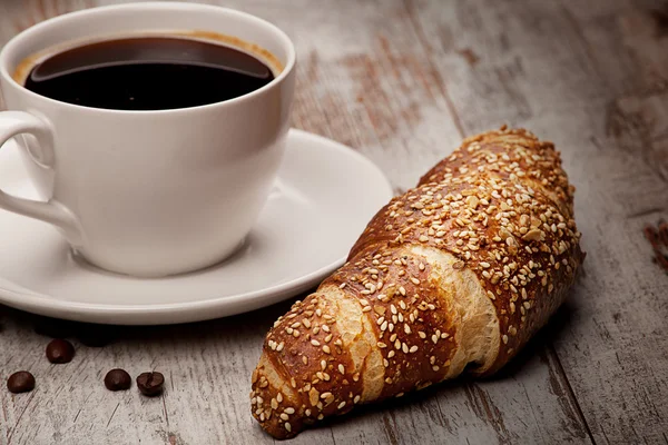 Tasse schwarzen Kaffee und Croissant — Stockfoto