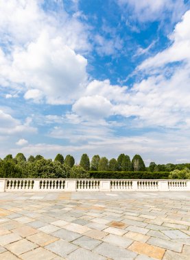 Dışarısı taştan yapılmış eski gri zeminli. Arka planda klasik desenli kaldırım ve mavi gökyüzü.