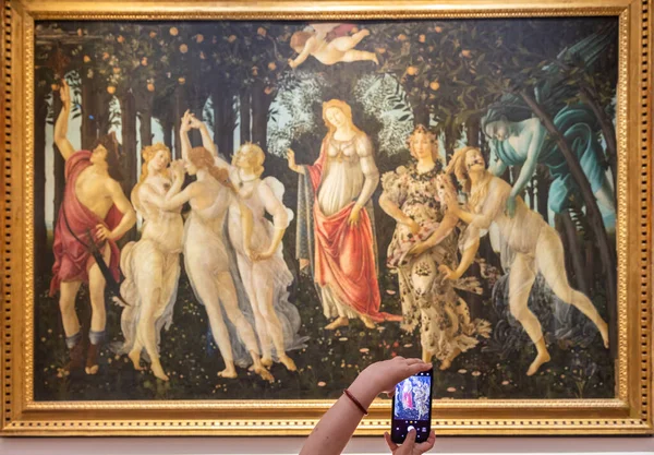 Floransa, İtalya - Temmuz 2021 dolaylarında. Turist Botticelli 'nin fotoğrafını çekiyor - Bahar. Kafkasyalı kadın elleri cep telefonuyla
