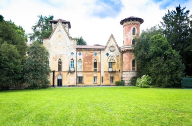 ITALY, MIRADOLO - CIRCA AĞOS 2020: Gün batımı ışığı ile gizem dolu bir İtalyan bahçesindeki gotik tasarım kalesi.