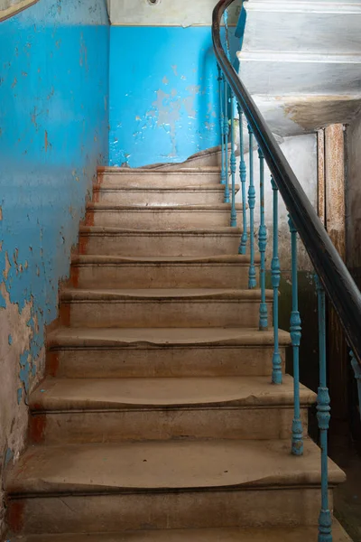 Antigua escalera de hormigón abandonada con hermosas barandillas en un edificio vacío con paredes azules — Foto de Stock