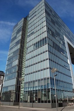 Original building with glass and steel cladding. It has an unusual shape and is located in the city of Cologne, Germany.