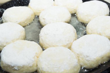 Taze hamur işleri yapma süreci. Kızartma tavasında süzme peynirli kekler..