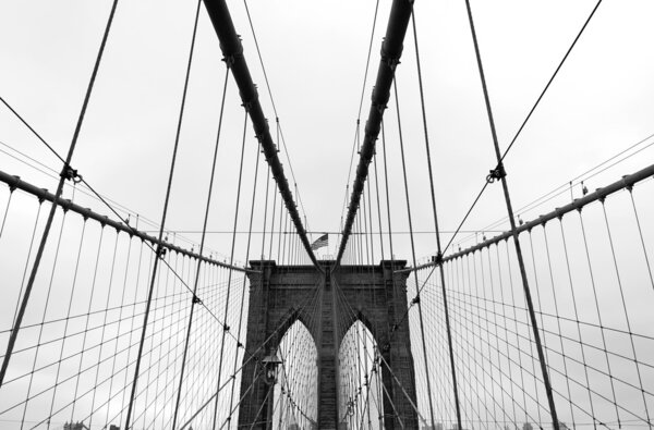 Black and white wide angle view of the Brooklyn Bridge in New York City.