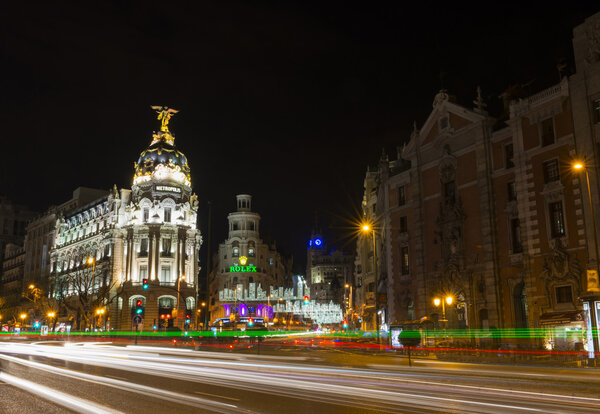 Night view of Madrid's Alcala and Gran Via streets illuminated by the traffic and the Christmas decorations. Several landmarks like the Metropolis Building, designed by French architects Jules and Raymond Fèvrier, or the Telefonica Building, designed