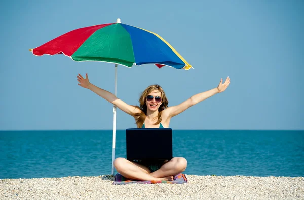 Девушка с ноутбуком на пляже — стоковое фото