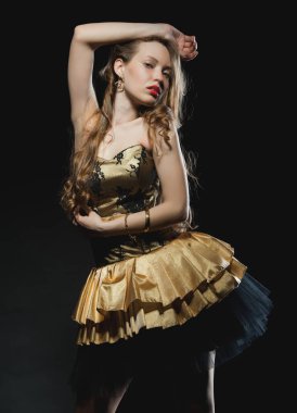 Güzel, seksi esmer kız siyah arka planda poz veriyor. Gece elbisesiyle.