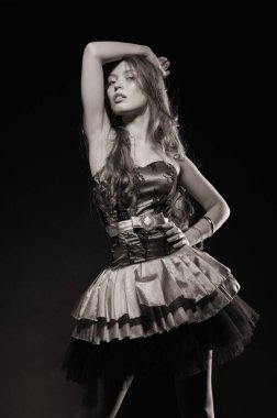 Beautiful sexy brunette girl posing on a black background in an evening dress