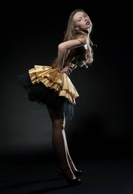 Güzel, seksi esmer kız siyah arka planda poz veriyor. Gece elbisesiyle.