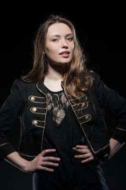 Güzel, seksi esmer kız siyah arka planda poz veriyor. Gece elbisesiyle.