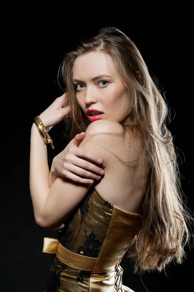 Güzel, seksi esmer kız siyah arka planda poz veriyor. Gece elbisesiyle.