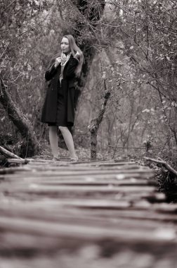 Sonbaharda ormanda poz veren uzun saçlı güzel seksi kız.