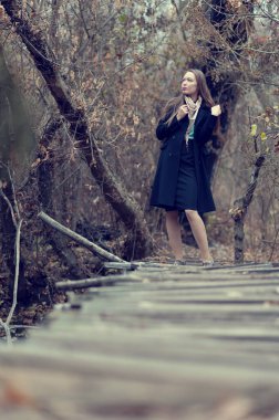 Sonbaharda ormanda poz veren uzun saçlı güzel seksi kız.