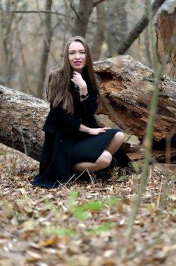 Sonbaharda ormanda poz veren uzun saçlı güzel seksi kız.