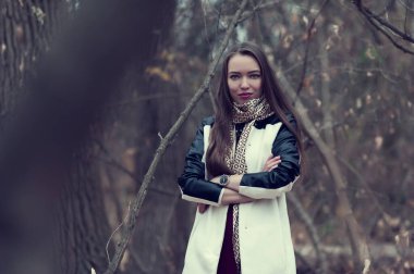 Beautiful sexy girl with long hair posing in the forest in late autumn