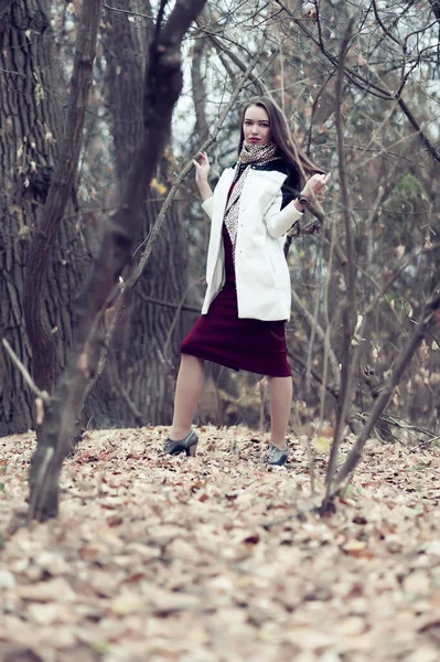 Sonbaharda ormanda poz veren uzun saçlı güzel seksi kız.