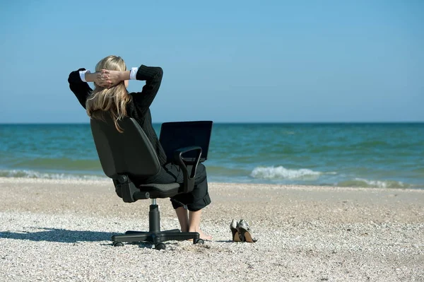 원격으로 일하는 노트북 컴퓨터와 사무실 의자를 가지고 해변에 사업하는 — 스톡 사진