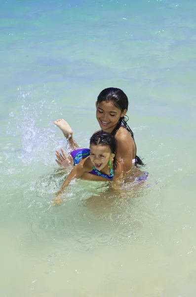 Полинезийские сестры, плавающие в океане — стоковое фото