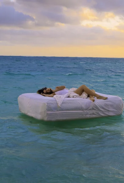Mujer en la cama a la deriva — Foto de Stock