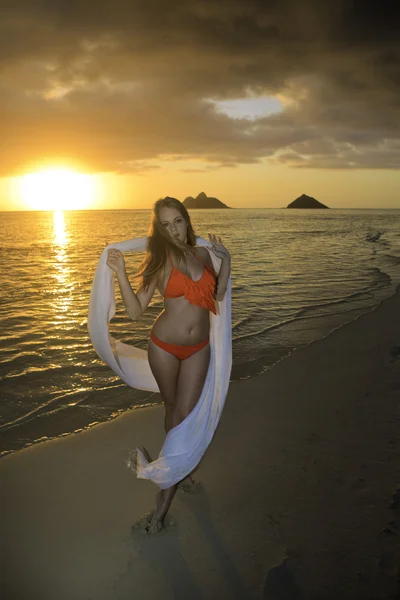 Flicka på stranden vid soluppgången — Stockfoto