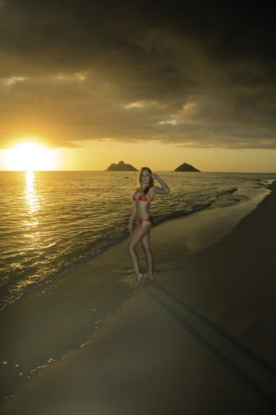 Meisje op het strand bij zonsopgang — Stockfoto