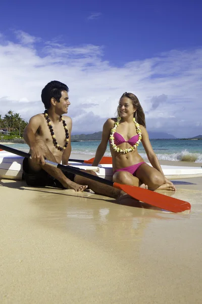 Couple on beach with surf skis — Stock Photo, Image