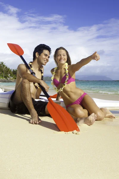 Couple on beach with surf skis — Stock Photo, Image