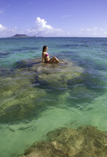 Girl sitting on coral reef — Stock Photo, Image