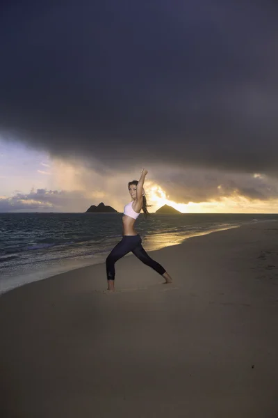 Kvinna tränar på stranden på sunrise — Stockfoto