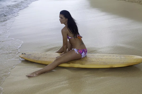 Vrouw aan het strand met surfboard — Stockfoto