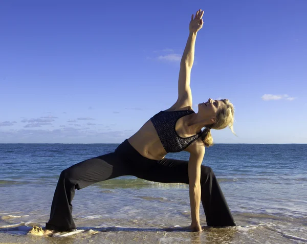 Vrouw doet yoga op het strand — Stockfoto