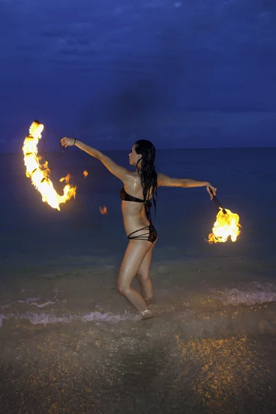 Donna con il fuoco sulla spiaggia di nottekobieta z ogniem na plaży w nocy — Zdjęcie stockowe