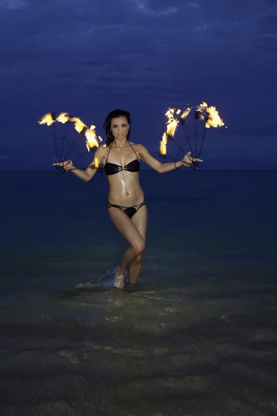 Frau mit Feuer am Strand in der Nacht — Stockfoto