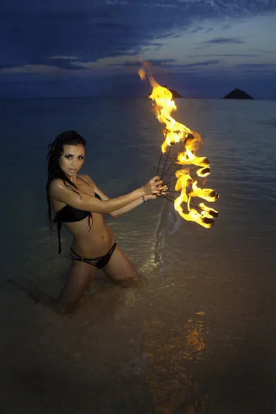 Žena s ohněm na pláži v noci — Stock fotografie
