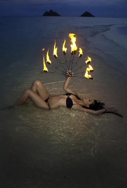 Woman with fire on the beach at night — Stock Photo, Image