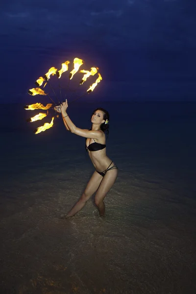 Frau mit Feuer am Strand in der Nacht — Stockfoto