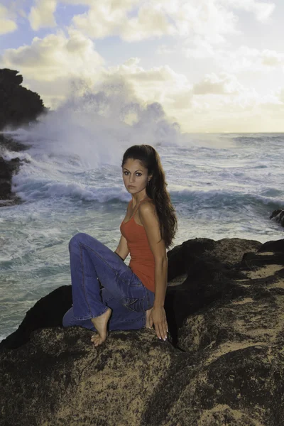 Mulher em rochas pelo oceano — Fotografia de Stock