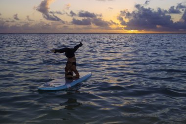 Yoga bir paddle kurulu yapıyor kadın