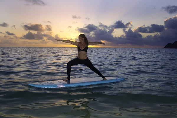 Kvinnan gör yoga på en paddla ombord — Stockfoto