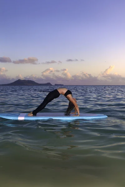 Donna che fa yoga su una pedana — Foto Stock