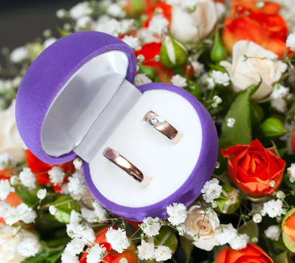 Gold wedding rings on a bouquet of flowers for the bride — Stock Photo © Alexust 55256839