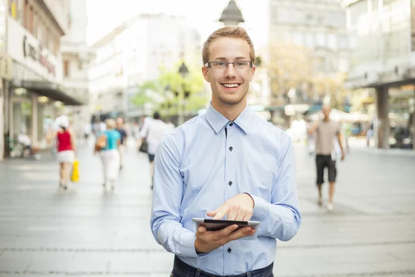 Giovane uomo con occhiali e tablet computer sulla strada — Foto Stock