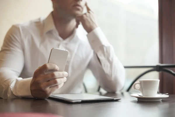 Affär med smartphone i café — Stockfoto