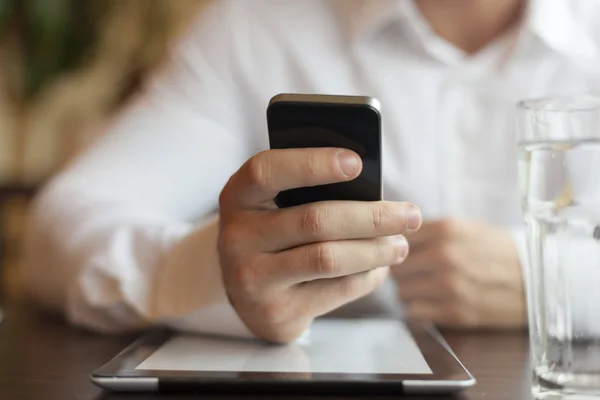 Man with smartphone and tablet computer in restaurant — Stock Photo, Image