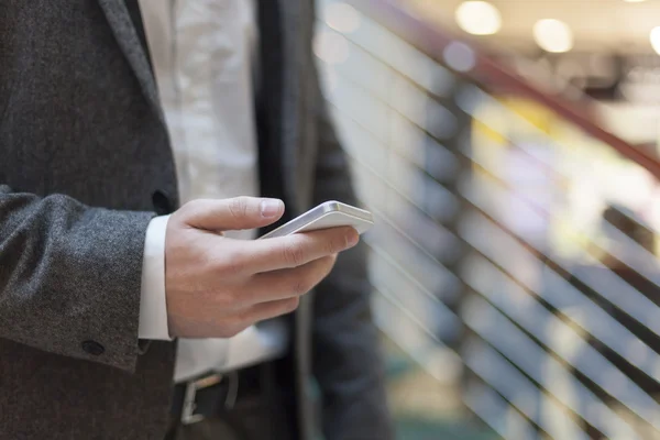 Businessman with smartphone in business building — Stock Photo, Image